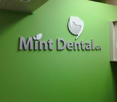 the mintt dental logo is displayed on a green wall