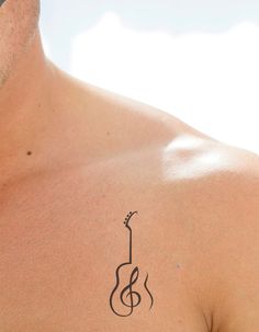 a man with a guitar tattoo on his chest