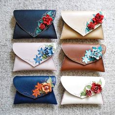 four different colored wallets with flowers on them