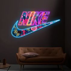 the nike logo is lit up with neon lights and flowers on it's side