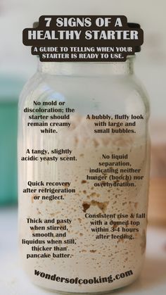 a jar filled with food sitting on top of a counter next to a sign that says 7 signs of a healthy starter