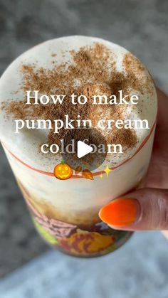 someone is holding up a cup filled with pumpkin cream