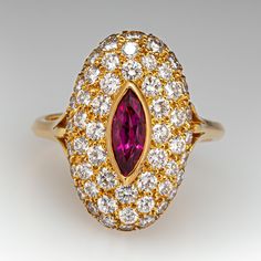 This elegant ring is centered with one (1), bezel set, marquise mixed cut natural ruby. The ruby is bordered with fifty-two (52), bead set, round brilliant cut diamonds. The ring has a reverse tapered "knife edge" style shank. The ring measures 19.5mm at the top, rises 7.7mm above the finger, tapering to 2.7mm wide and 1.6mm thick at the base of the shank. This ring is currently a size 6.75. The ring shows a lovely soft patina. Luxury Marquise Ruby Ring With Diamonds, Luxury Marquise Red Ruby Ring, Luxury Ruby Marquise Cut Rings, Classic Marquise Ruby Ring With Brilliant Cut, Luxury Red Marquise Ruby Ring, Marquise Ruby Ring With Diamonds, Classic Marquise Ruby Ring With Center Stone, Marquise Ruby Ring With Center Stone, Formal Marquise Ruby Ring With Diamond