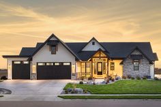 a large house with two garages in front of it at sunset or sunrise time