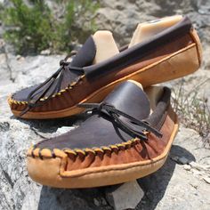 "This unique men's canoe sole moccasin is handcrafted from a brown distressed leather with a contrasting toast colored suede and has a double sole. The toe plug and collar are constructed of a 6 ounce brown distressed cow hide with the vamp constructed of a 4-5 ounce soft suede cow hide and a 7-9 ounce cow hide canoe sole. If you desire an even heavier sole select \"request custom order\" stating your request for bull hide which will be an additional $28.00. The double sole adds to the durabilit Rugged Moccasins With Stitched Sole, Rugged Moc Toe Moccasins For Outdoor, Rugged Moccasins With Stitched Sole And Moc Toe, Rugged Brown Slip-on Loafers, Brown Moc Toe Loafers For Outdoor, Brown Slip-on Loafers With Vibram Sole, Rugged Leather Moccasins With Plain Toe, Rugged Loafers With Leather Sole, Brown Leather Moccasins With Vibram Sole