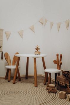 two chairs and a table in a room with bunting on the wall behind them