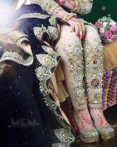 a woman sitting on top of a bench wearing elaborate clothing