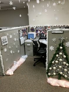 two cubicles decorated with christmas decorations and snowflakes on the walls, one has a tree