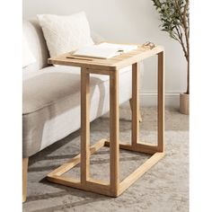 a wooden table sitting on top of a carpeted floor next to a white couch