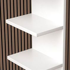 two white shelves against a brown wall with vertical stripes on the wall behind them, one shelf is empty