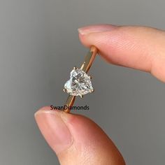 a person holding a diamond ring in their hand