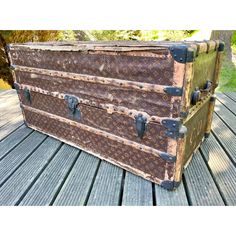 an old trunk sitting on top of a wooden deck