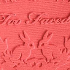 a close up view of some pink powder with the word too faced written on it