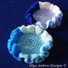 two crocheted bowls sitting on top of a blue surface