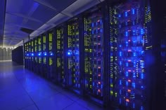 rows of servers in a data center with blue and yellow lights on the side wall