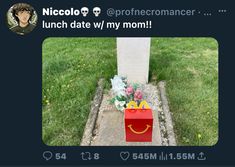 a red bag sitting on top of a sidewalk next to a grave with a smile drawn on it