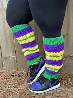 the legs and ankles of a person wearing colorful knitted leg warmers with sneakers on them