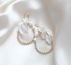 Elevate your bridal look with our stunning gold teardrop hoop earrings. The intricate floral design and elegant pearls make a bold statement that will add a touch of sophistication to any bridal style. Perfect for the stylish and modern bride. - Handcrafted in my PA studio  - Genuine white opal Austrian crystals - Freshwater pearls - Polymer clay flowers and leaves - Yellow gold finish is pictured. Available in rose gold, yellow gold or rhodium (silver) - Earrings measure 2.5 inches x 1.5 inch - Handcrafted in the US. - Nickel free and hypoallergenic - PLEASE ALLOW APPROX 10 BUSINESS DAYS FOR COMPLETION BEFORE SHIPPING. This is an original design by © Treasures by Agnes Browse our earrings: https://www.etsy.com/shop/treasures570?ref=seller-platform-mcnav&section_id=6861728 Browse our backd White Hoop Bridal Earrings For Formal Occasions, White Teardrop Hoop Earrings For Wedding, White Hoop Bridal Earrings For Wedding, Elegant Wedding Flower Hoop Earrings, Bridal Jewelry Pearl Earrings, Pearls And Flowers, Bridal Jewelry Pearl, Jewelry Pearl Earrings, Bridal Backdrop Necklace