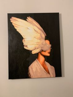 a painting of a woman with white hair and wings on her head is hanging on the wall