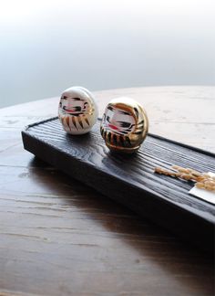 two decorative objects sitting on top of a wooden table