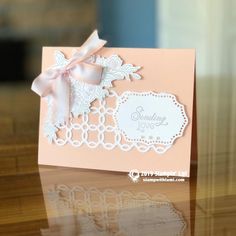 a close up of a greeting card on a table with a ribbon and bow around it