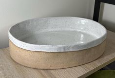 a white bowl sitting on top of a wooden table