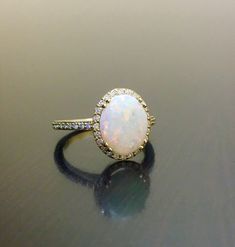 an opal and diamond ring on a table