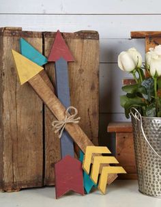 a metal bucket filled with flowers next to wooden arrows