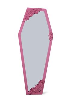 a pink mirror with roses on it and a white wall in the backround