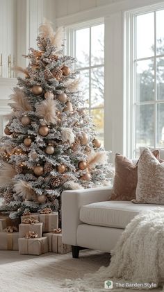 a white christmas tree with gold ornaments in a living room