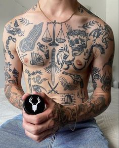 a shirtless man with tattoos on his chest holding an object in front of him