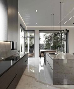 a modern kitchen with marble counter tops and stainless steel appliances, along with large sliding glass doors