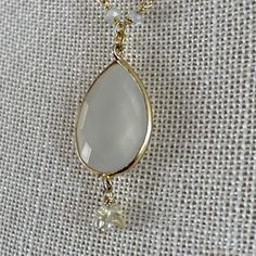 "Lab Created Opalite Opal gemstone pendant on a 3mm hand wired moonstone pear shaped bead necklace (hardwired by me), each bead is hand wired with gold plated over sterling silver. Lobster clasp for secure closure. Crystal stone dangle accent. Approx. 1 1/4\" Tall by 3/4\" Wide Opal Created Opaline Pendant Gold Plated over Sterling Silver Wirewrapped Approx. 18 1/2\" Long Chain Necklace Approx. 3mm moonstone rondell bead necklace REF: \"Opalite Moonstone Wirewrap\" Necklace NOTE: If you wish to Adjustable Gold Chalcedony Jewelry, Gold Faceted Chalcedony Jewelry, Gold Moonstone Teardrop Pendant Jewelry, Wire Wrapped Teardrop Pendant Necklace, Gold Teardrop Drop Necklace With Natural Stones, Wire Wrapped Teardrop Necklaces For Jewelry Making, Gold Wire Wrapped Drop Necklaces, Gold Wire Wrapped Drop Necklace, Gold Moonstone Crystal Necklaces With Gemstone Beads