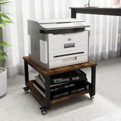 a printer sitting on top of a table next to a potted plant