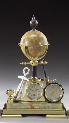 an antique clock with a globe on top and keys attached to the pendulums is shown