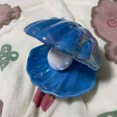 a blue flower shaped object sitting on top of a bed