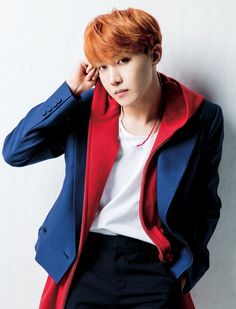 a young man with red hair wearing a blue jacket and white t - shirt, leaning against a wall