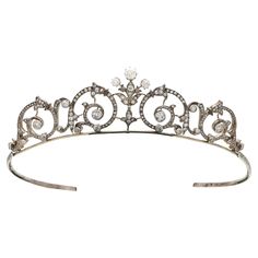 A truly elegant Edwardian old cut diamond tiara set in silver and gold, circa 1910. This beautifully handcrafted tiara is composed of a number of elegant foliate scroll motifs, commonly seen within the Victorian and Edwardian jewellery eras. The tiara is centred with a fleur-de-lis inspired spray, topped with the three largest old mine cut diamonds in the tiara. There is a grand total of 264 diamonds set within the piece and due to the spread of the design sparkles from all angles. This tiara is Diamond Headpiece, Tiara Diamond, Tiara Gold, Tiaras Jewellery, Pearl Tiara, Edwardian Jewelry, Diamond Tiara, Gold For Sale, God Save The Queen