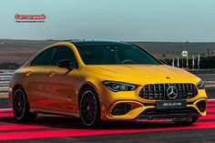 a yellow mercedes cla driving on a race track