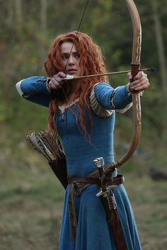 a woman with red hair holding a bow and arrow