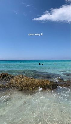 people are swimming in the ocean near rocks