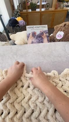 a person is knitting on a blanket in the living room