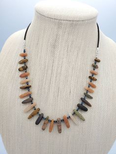 "This beautiful Boho necklace is designed with a mix of natural gemstones, Czech seed beads and dark brown leather cord. The gemstone mix includes Tiger's eye, Unakite and pink Aventurine. The length of the stone beads is 10 to 20mm. The gemstones have very nice matte finish. The necklace is 20.0 inches long. It's finished with silver plated lobster clasp and 2\" extender chain." Earthy Brown Beaded Necklaces With Gemstones, Earthy Brown Beaded Gemstone Necklaces, Adjustable Brown Gemstone Beaded Necklaces, Unique Adjustable Brown Crystal Necklace, Unique Brown Adjustable Crystal Necklace, Earthy Necklace With Adjustable Cord For Healing, Brown Adjustable Cord Jewelry For Healing, Brown Beaded Necklaces With Stones, Artisan Brown Crystal Necklaces With Natural Stones