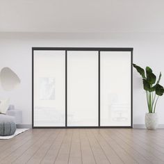 an empty living room with white walls and wooden flooring, large sliding glass doors to the outside