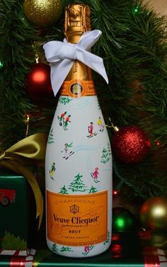 a bottle of wine sitting next to a christmas tree