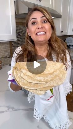 a woman is holding some food in her hands