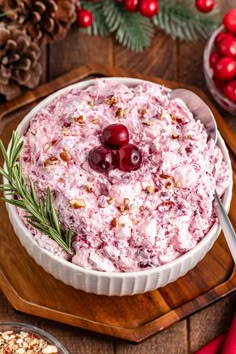 a bowl filled with cranberry salad on top of a wooden cutting board