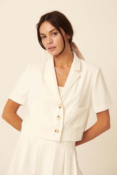 Solid-color blazer jacket. Notch lapel collar. Short sleeves. Lightly padded shoulder. Button-front closure with tortoise buttons. Front pockets. Cropped length. Lined. Relaxed fit. 100% Polyester. Imported. Designed in LA. Model wears size S. Ladies Tops, Tops Fashion, Cropped Blazer, Dress Gift, White Blazer, Ladies Tops Fashion, Clothing Boutique, Lapel Collar, How To Feel Beautiful