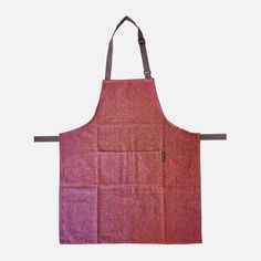 a red apron hanging on the wall with an empty pocket for it to hold something