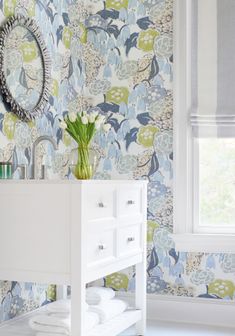 a white sink sitting next to a window in a bathroom